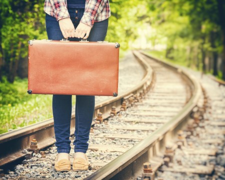girl with retro vintage suitcase on railway, retro stylized