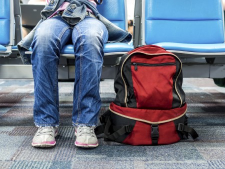 Passenger traveler woman in airport waiting for air travel with backpack